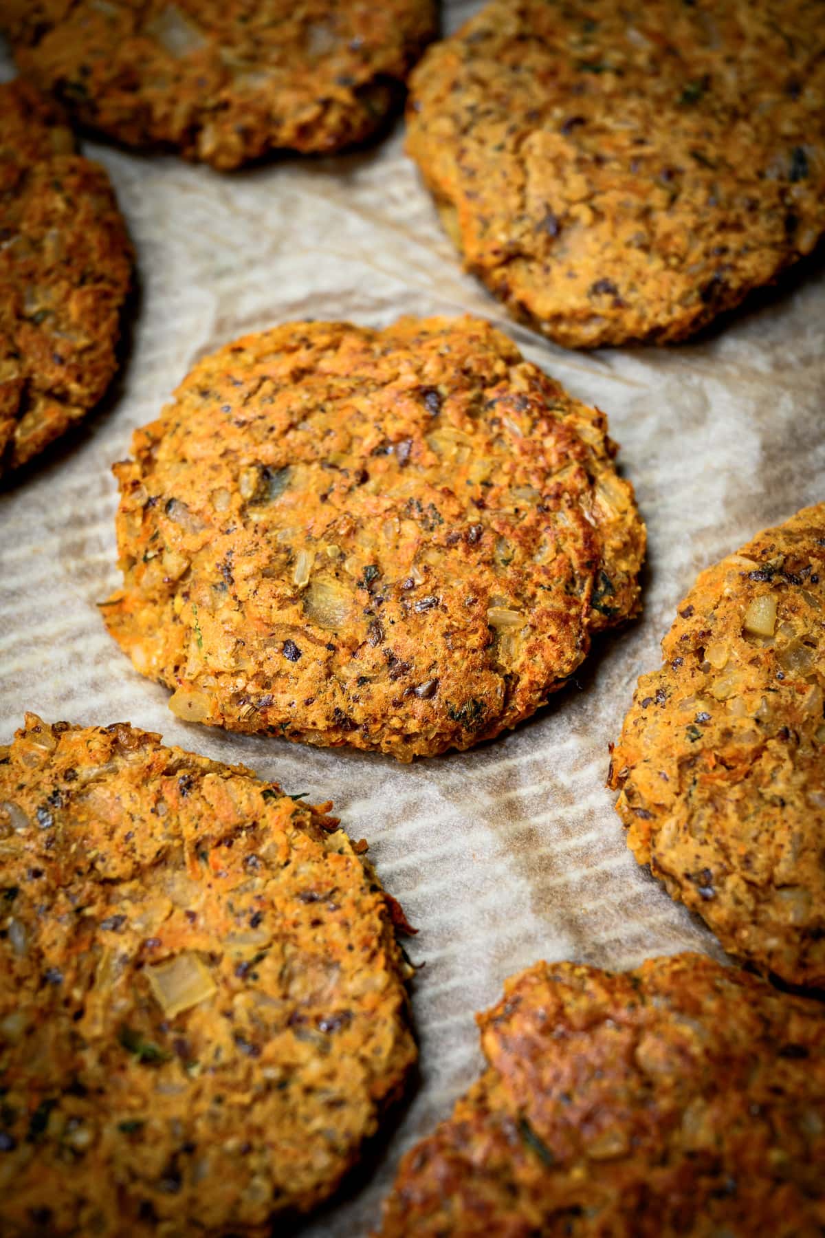 side view of cooked indian-spiced veggie burgers on parchment paper