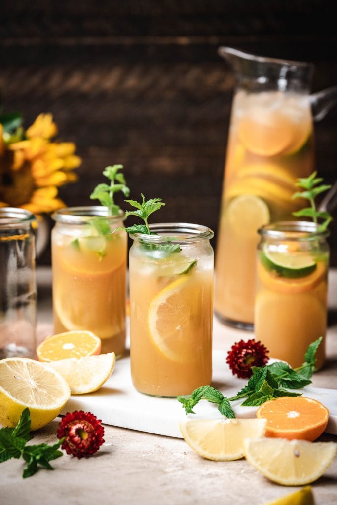 side view of long island iced tea garnished with fresh lemon and mint