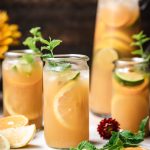 side view of long island iced tea garnished with fresh lemon and mint