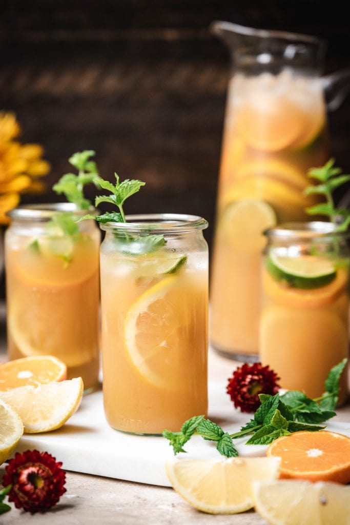 side view of long island iced tea garnished with fresh lemon and mint