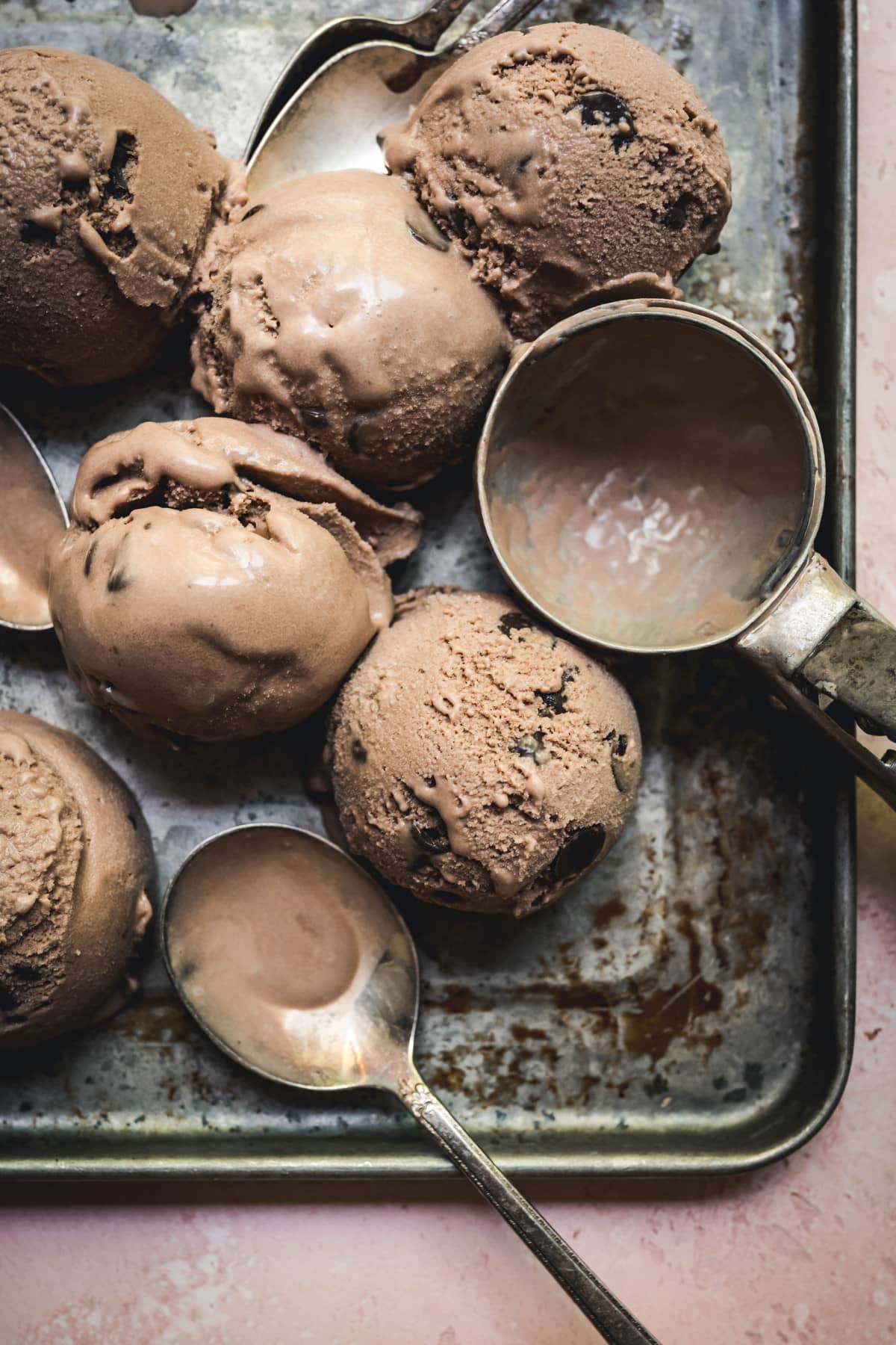 overhead of scoops of vegan mocha ice cream with an ice cream scoop and spoon on a tray