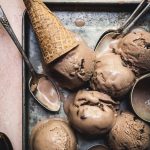overhead of vegan mocha ice cream scoops on a try with ice cream cones