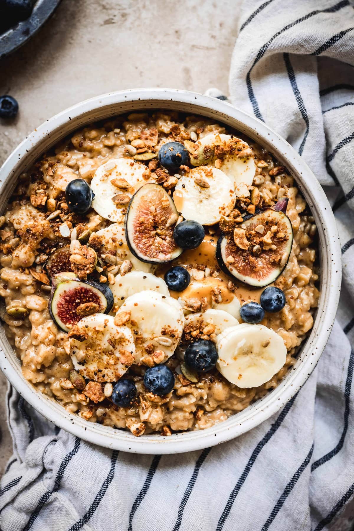 close up overhead of pumpkin pie oatmeal with peanut butter and bananas