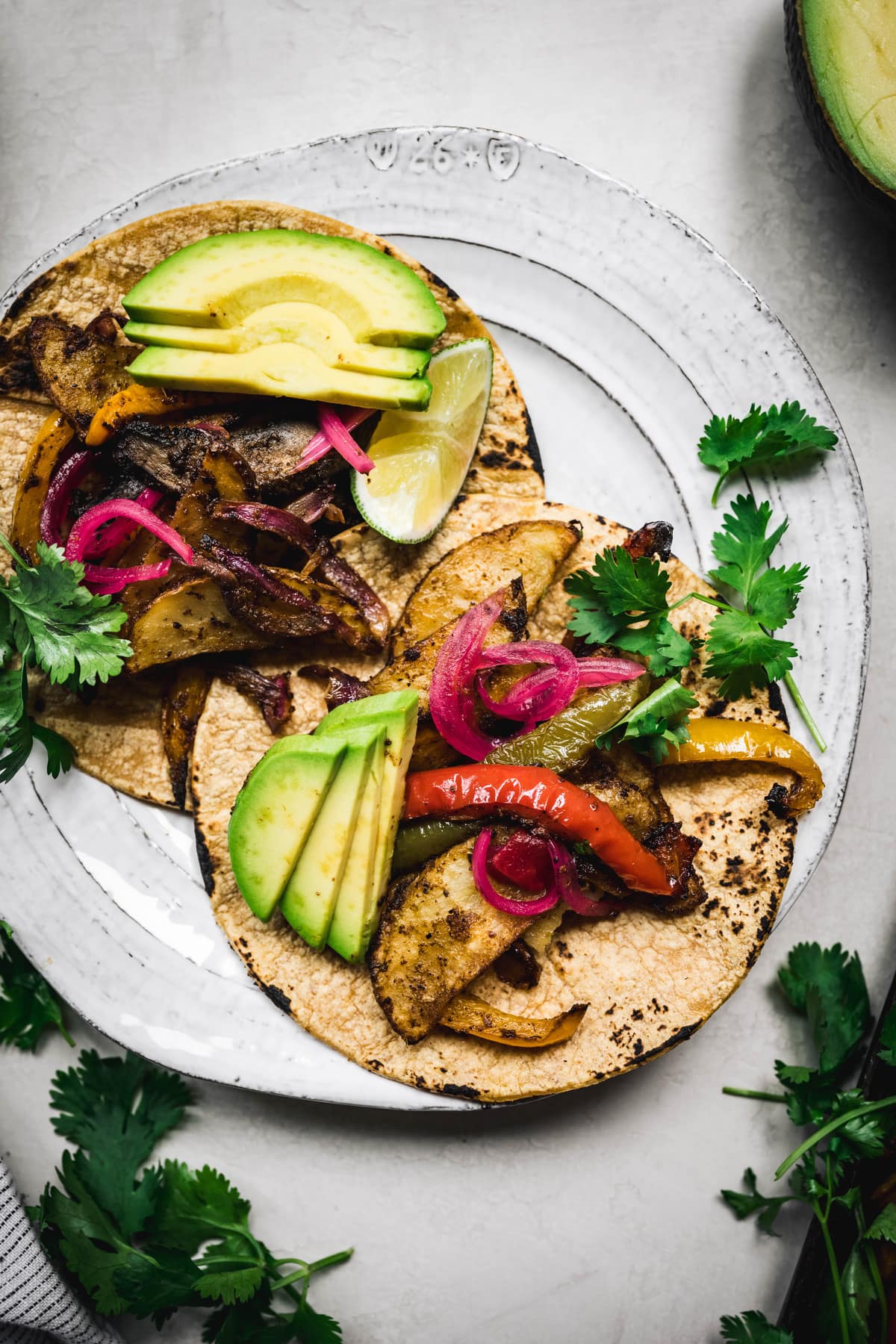 overhead of two vegan portobello fajitas on a white plate