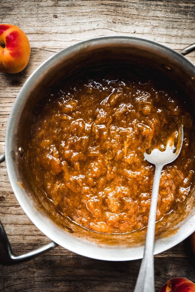 overhead of homemade apricot jam filling in saucepan