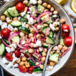 overhead of cucumber chickpea salad in a white bowl with a fork