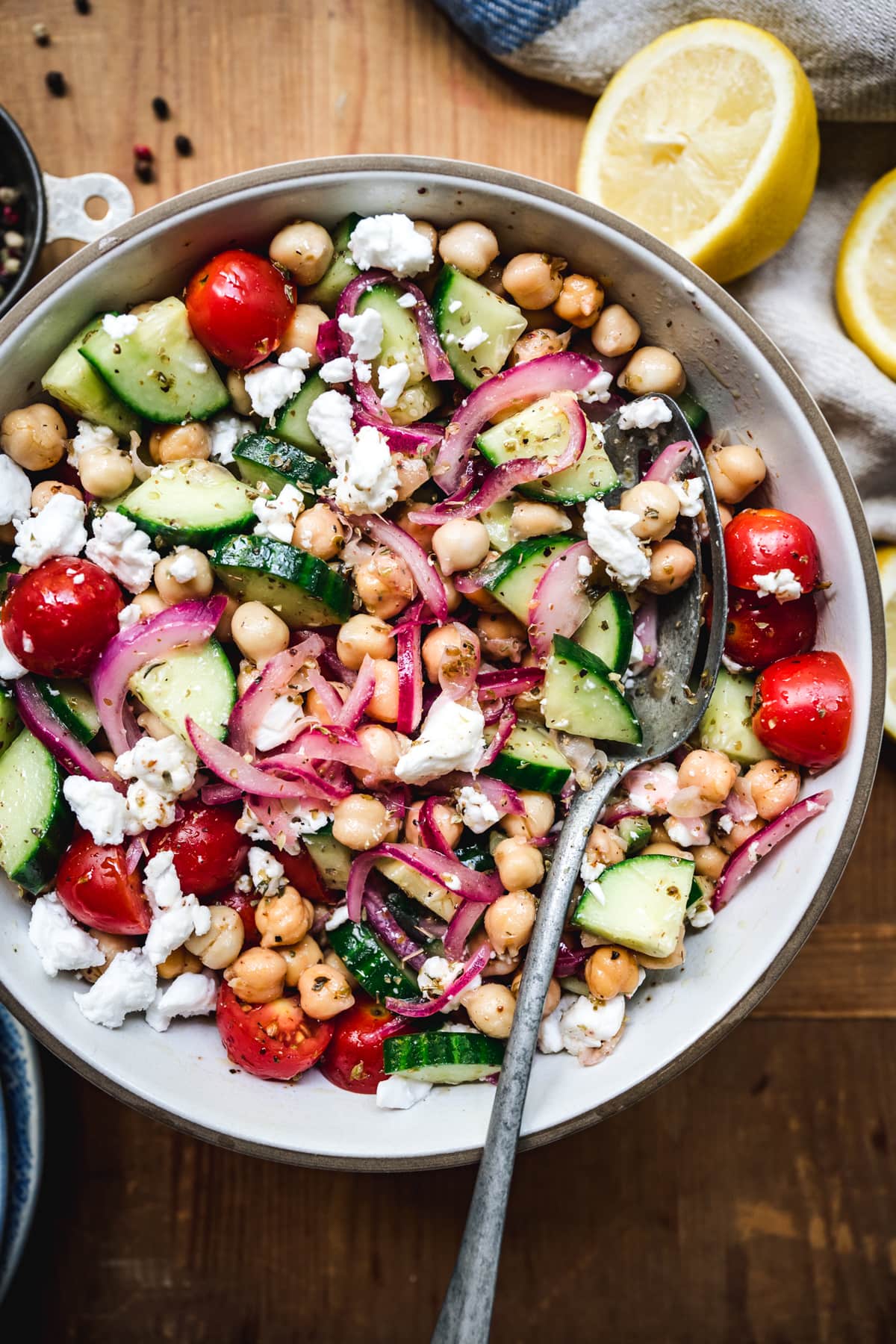 overhead of cucumber chickpea salad in a white bowl with a fork