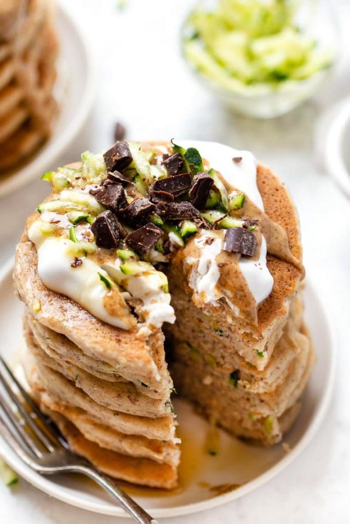 45 degree overhead of a stack of healthy zucchini pancakes made with quinoa flour topped with chocolate