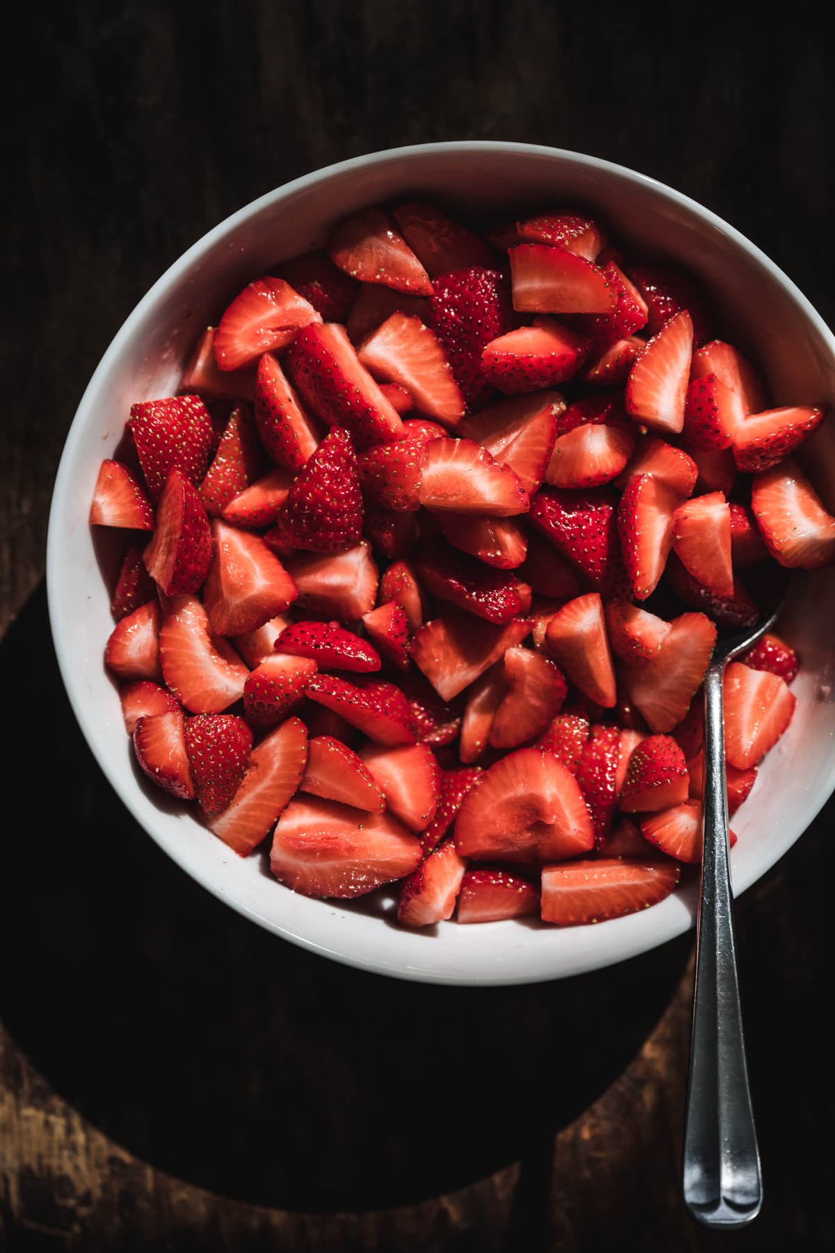 overhead of fresh sliced strawberries in a bowl