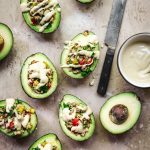 overhead view of mediterranean stuffed avocados with vegan tahini dressing