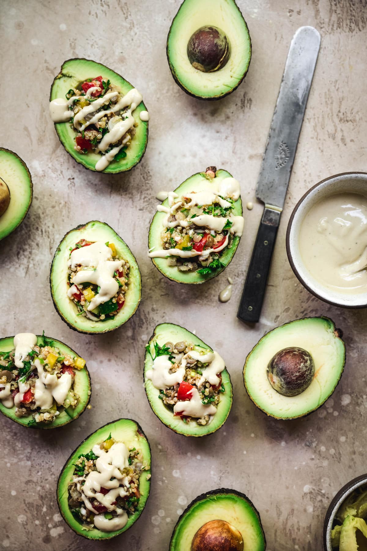 overhead view of mediterranean stuffed avocados with vegan tahini dressing