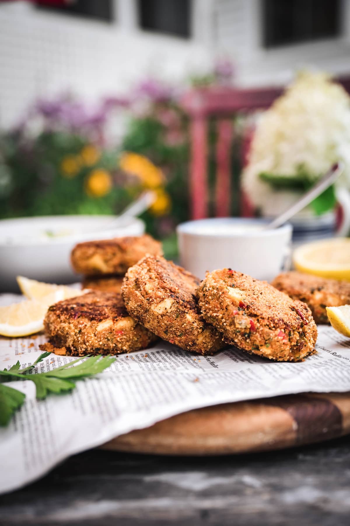 side view of vegan crab cakes on newspaper in a garden