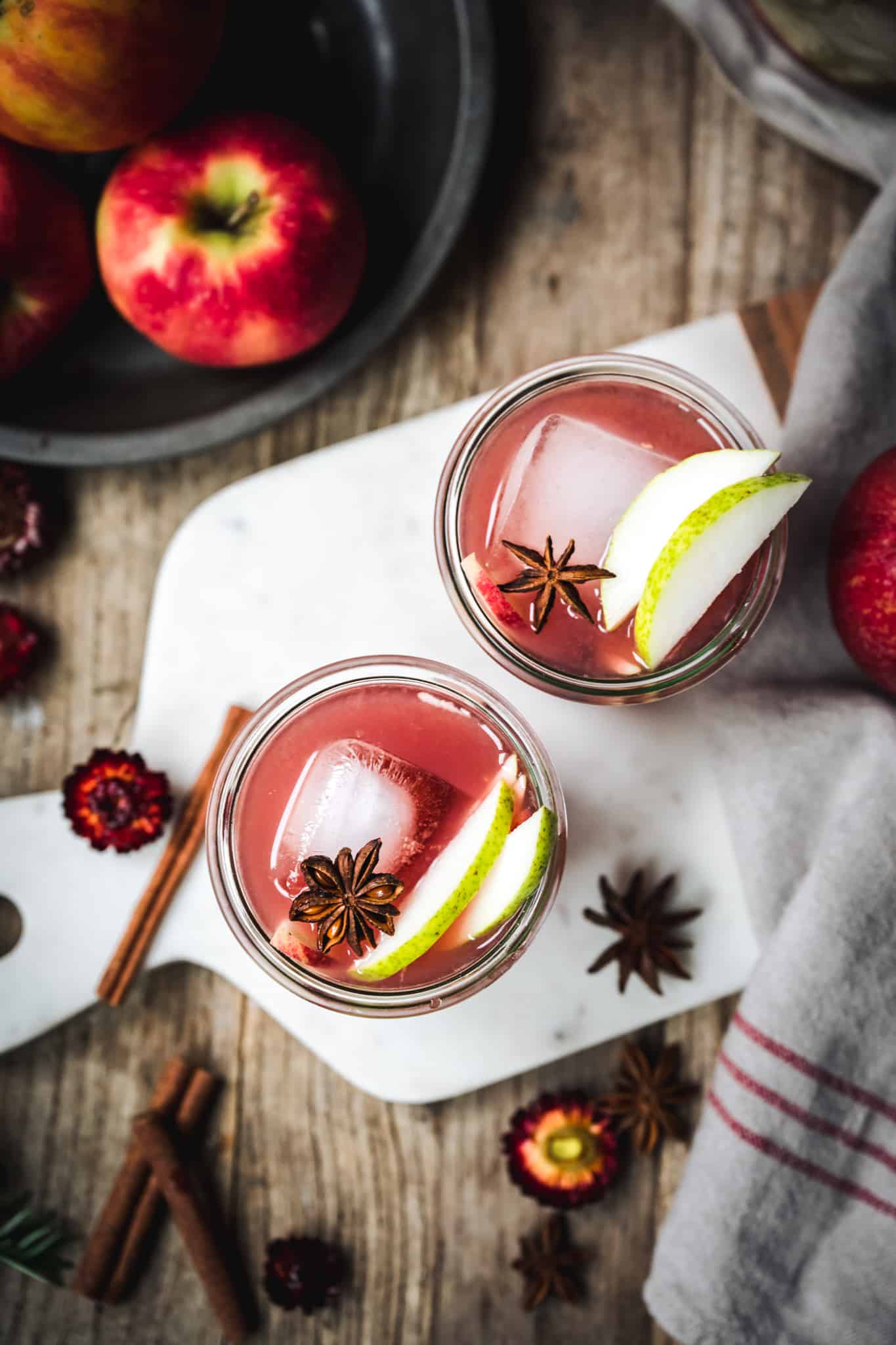 overhead view of two glasses of pear vodka cocktails garnished with apple slices