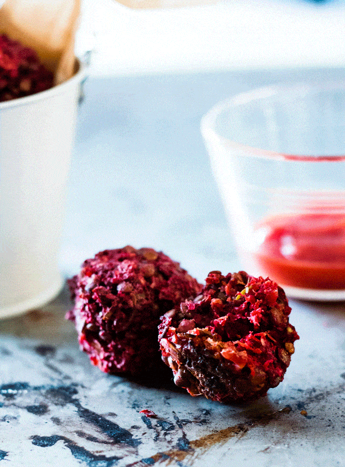 side view of two game day beet balls with ketchup in the background