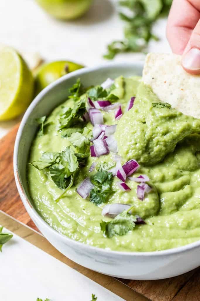45 degree close up of guacomle salsa with a tortilla chip