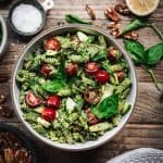 overhead view of pesto pasta salad with summer vegetables in white bowl