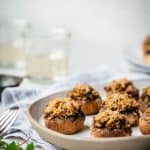 Stuffed mushrooms on a plate seen from the side.