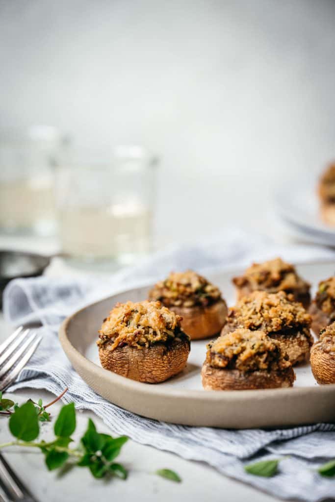 Side view of vegan stuffed mushrooms on a white platter