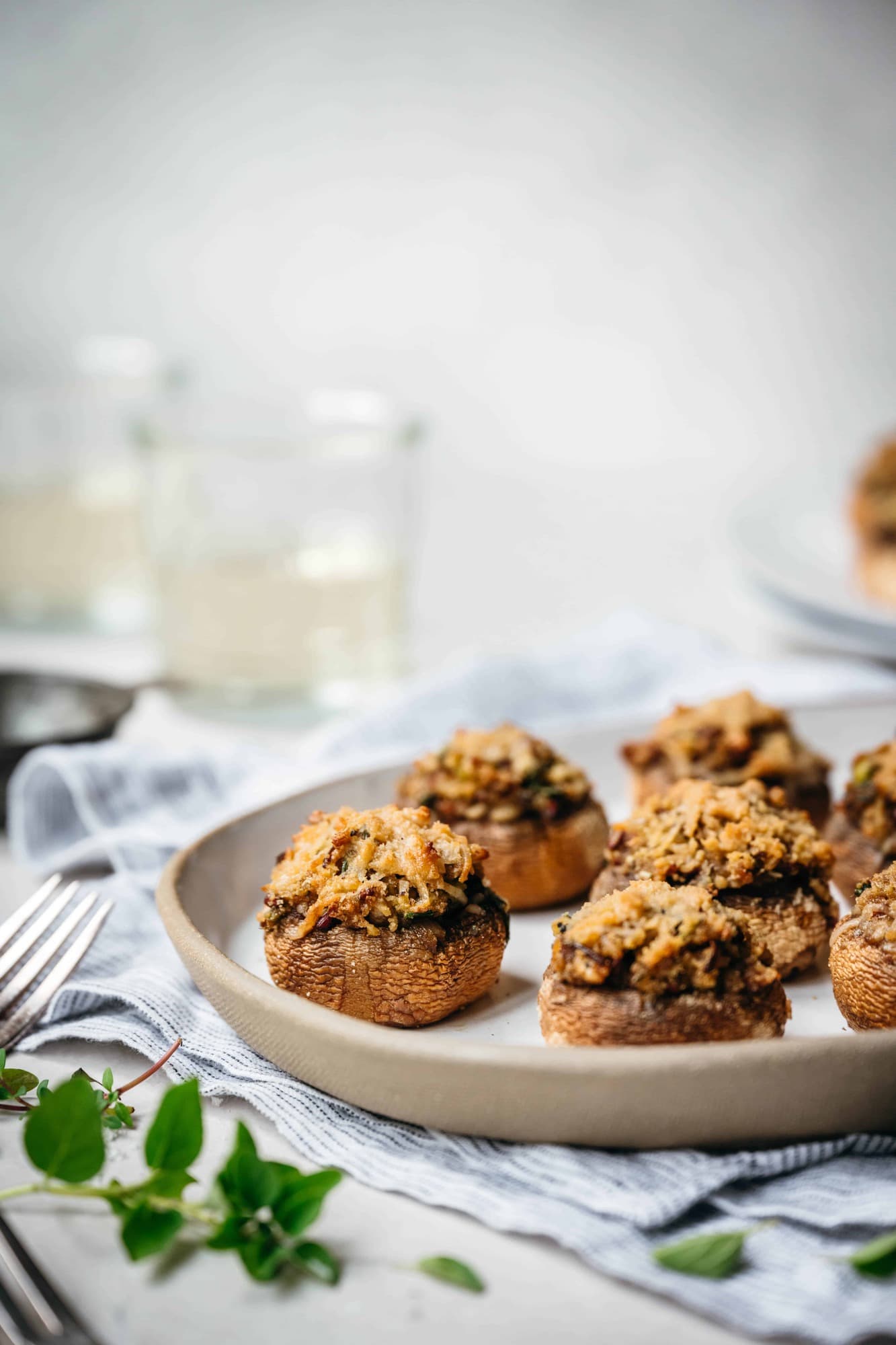 Side view of vegan stuffed mushrooms on a white platter