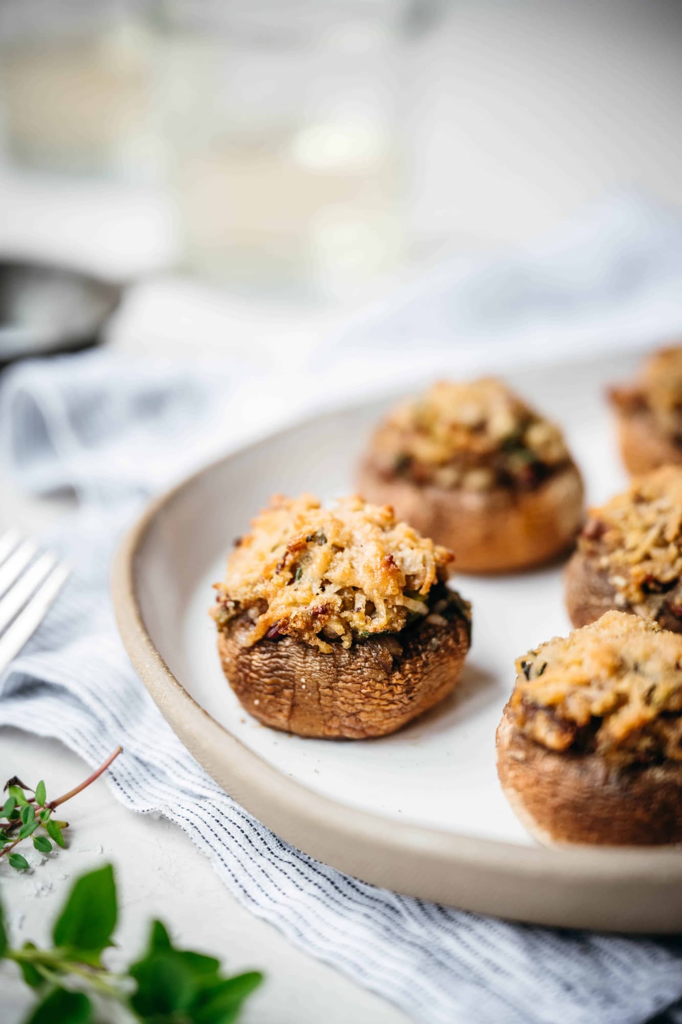 close up side view of vegan stuffed mushrooms on white platter