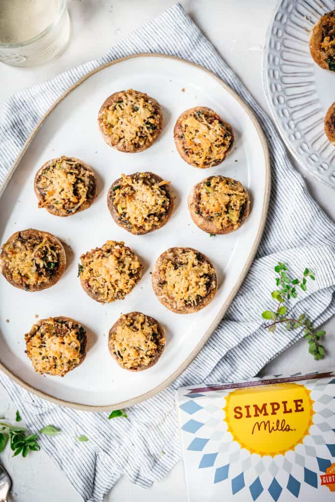 overhead view of vegan and gluten free stuffed mushrooms on white platter