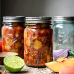 side view of peach tomato salsa in ball caning jars