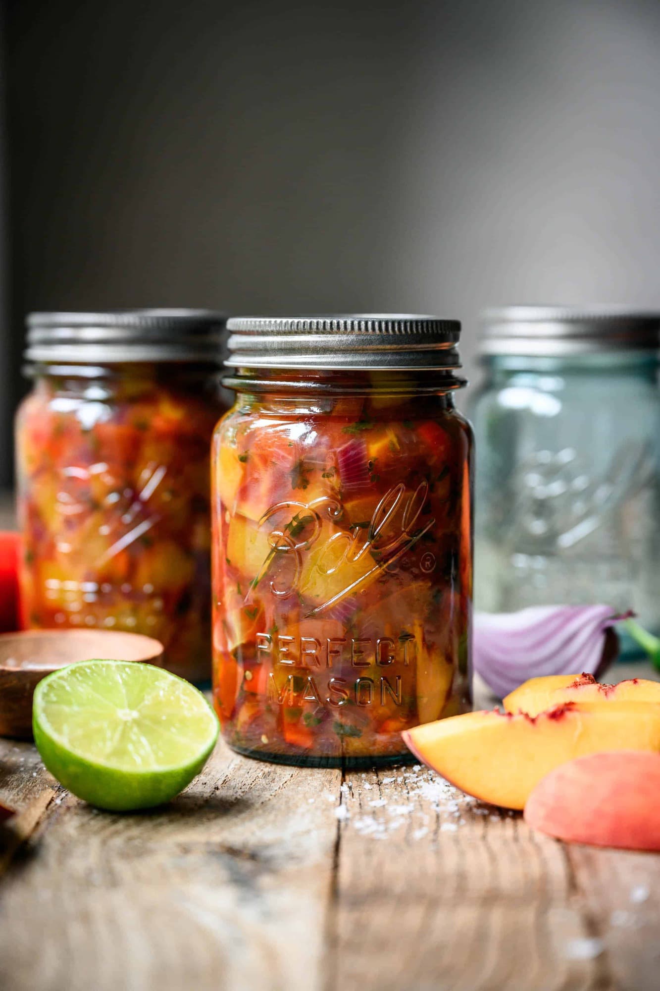 side view of peach tomato salsa in ball caning jars