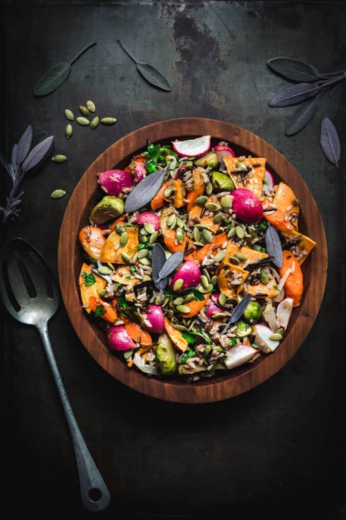 overhead of a bowl of harvest salad with wild rice and roasted vegetables in a wooden bowl