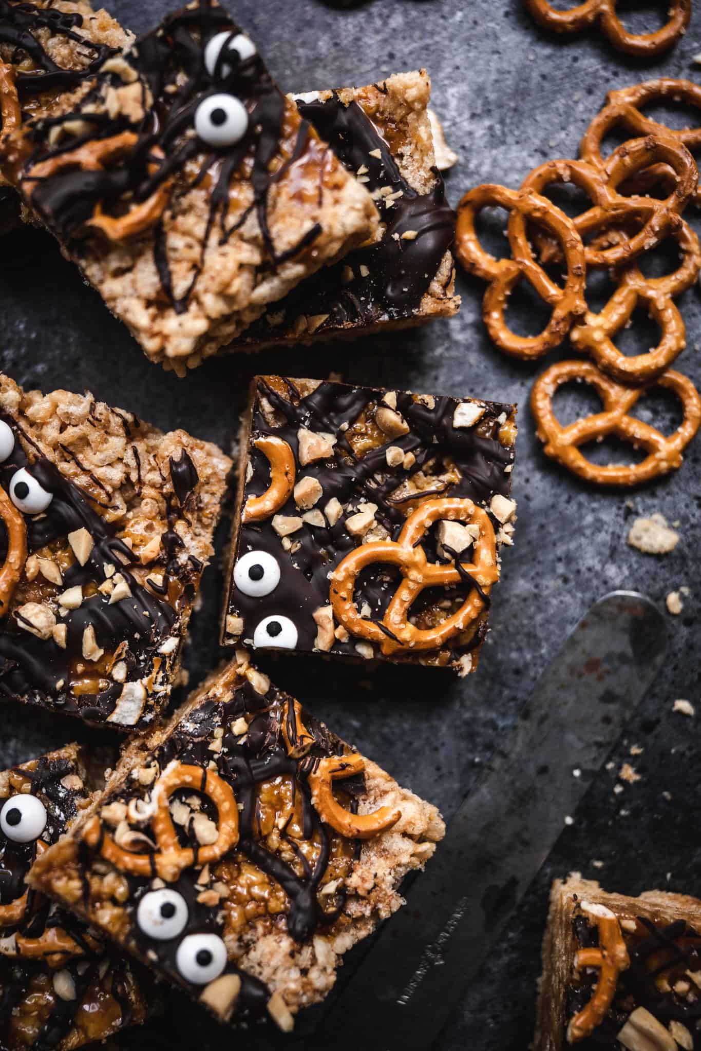 close up overhead of a halloween rice krispie treat topped with pretzels, caramel and chocolate