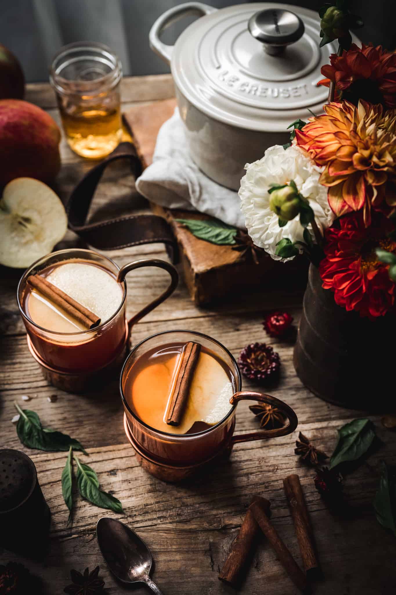 45 degree angle of hot apple cider brandy cocktail on wood backdrop