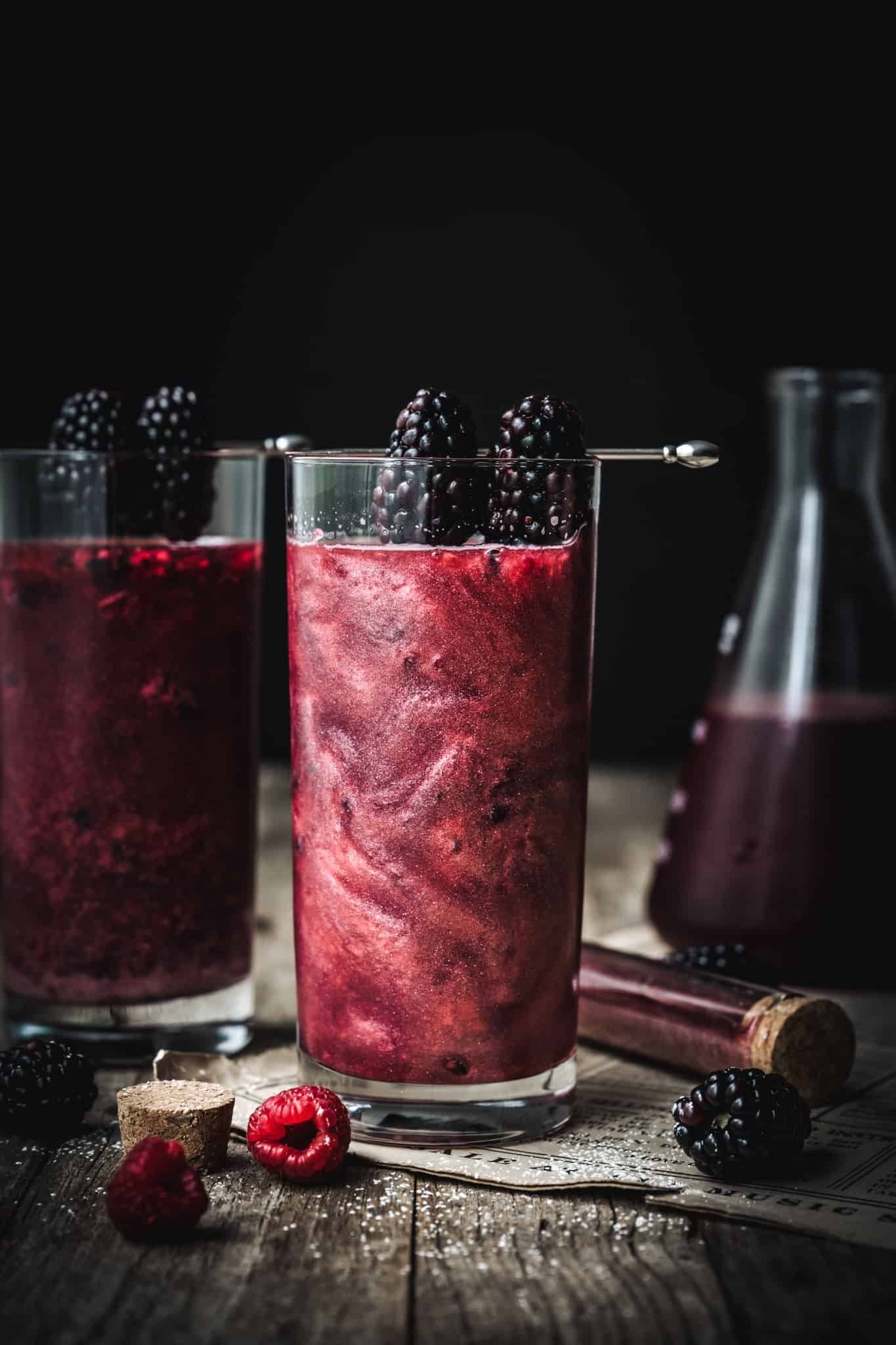 side view of halloween tequila cocktail garnished with blackberries