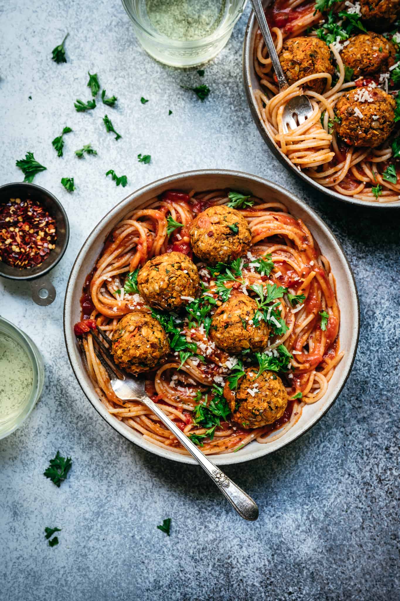overhead of vegan lentil meatballs in red sauce with spaghetti in a bowl
