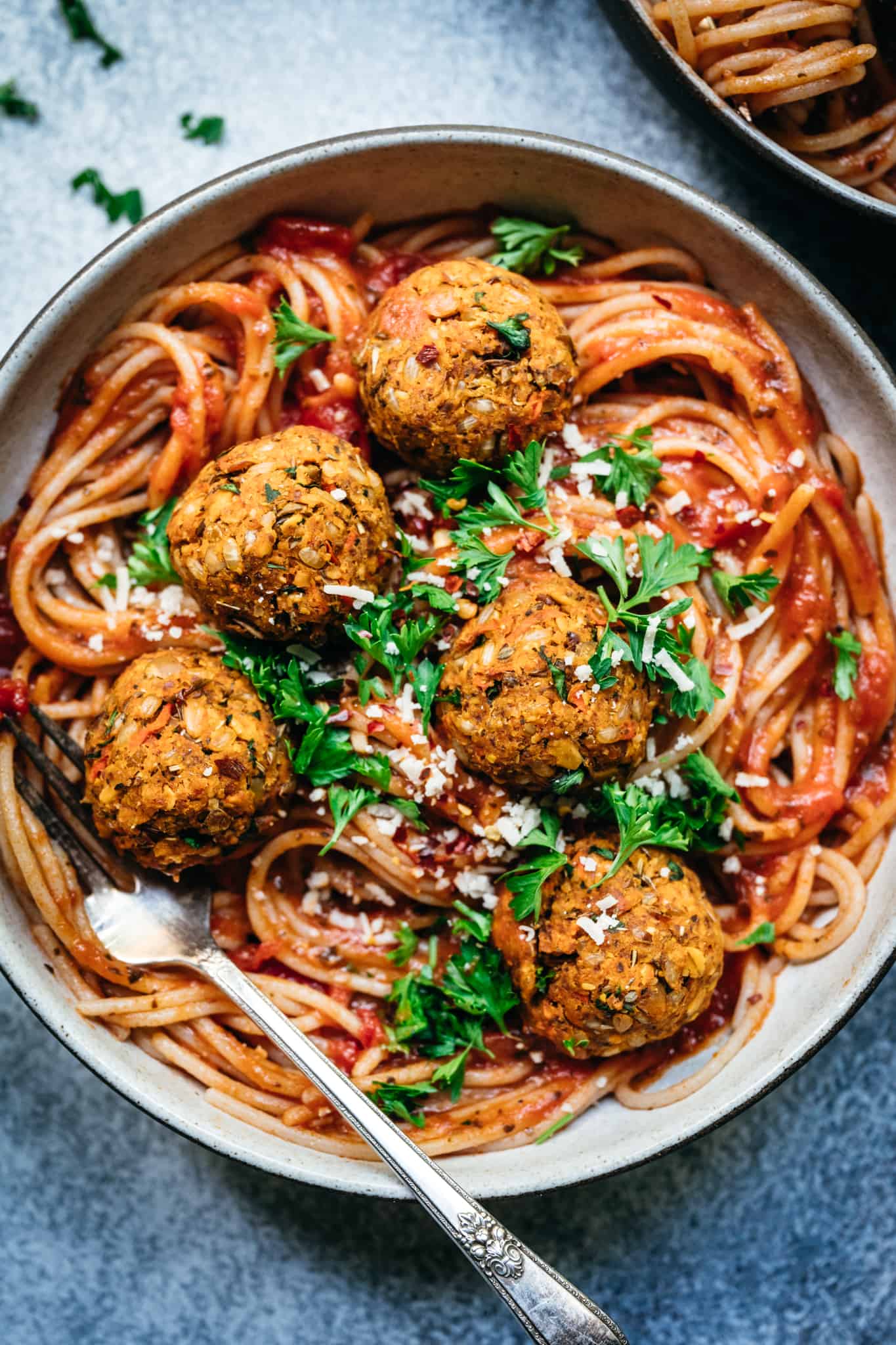 overhead closeup of veganf lentil meatballs on spaghetti with tomato sauce