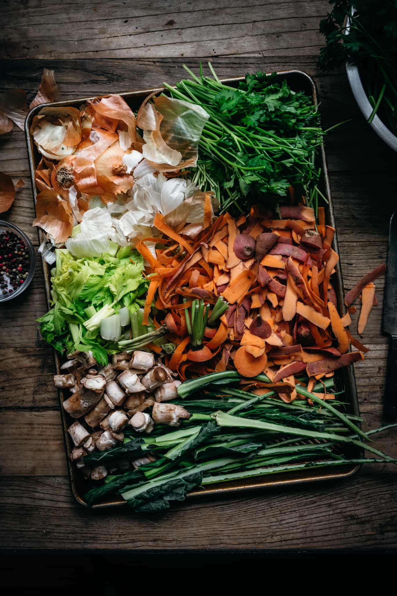 overhead view of vegetable scraps on sheet pan to make vegetable broth