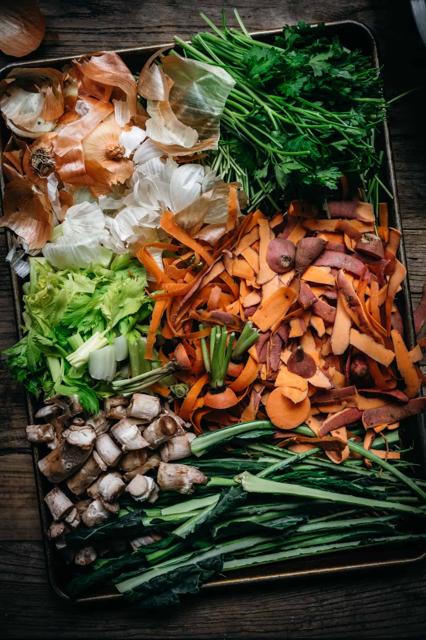 overhead view of vegetable scraps on sheet pan to make vegetable broth