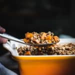 Side view of lifting sweet potato bake out of casserole dish
