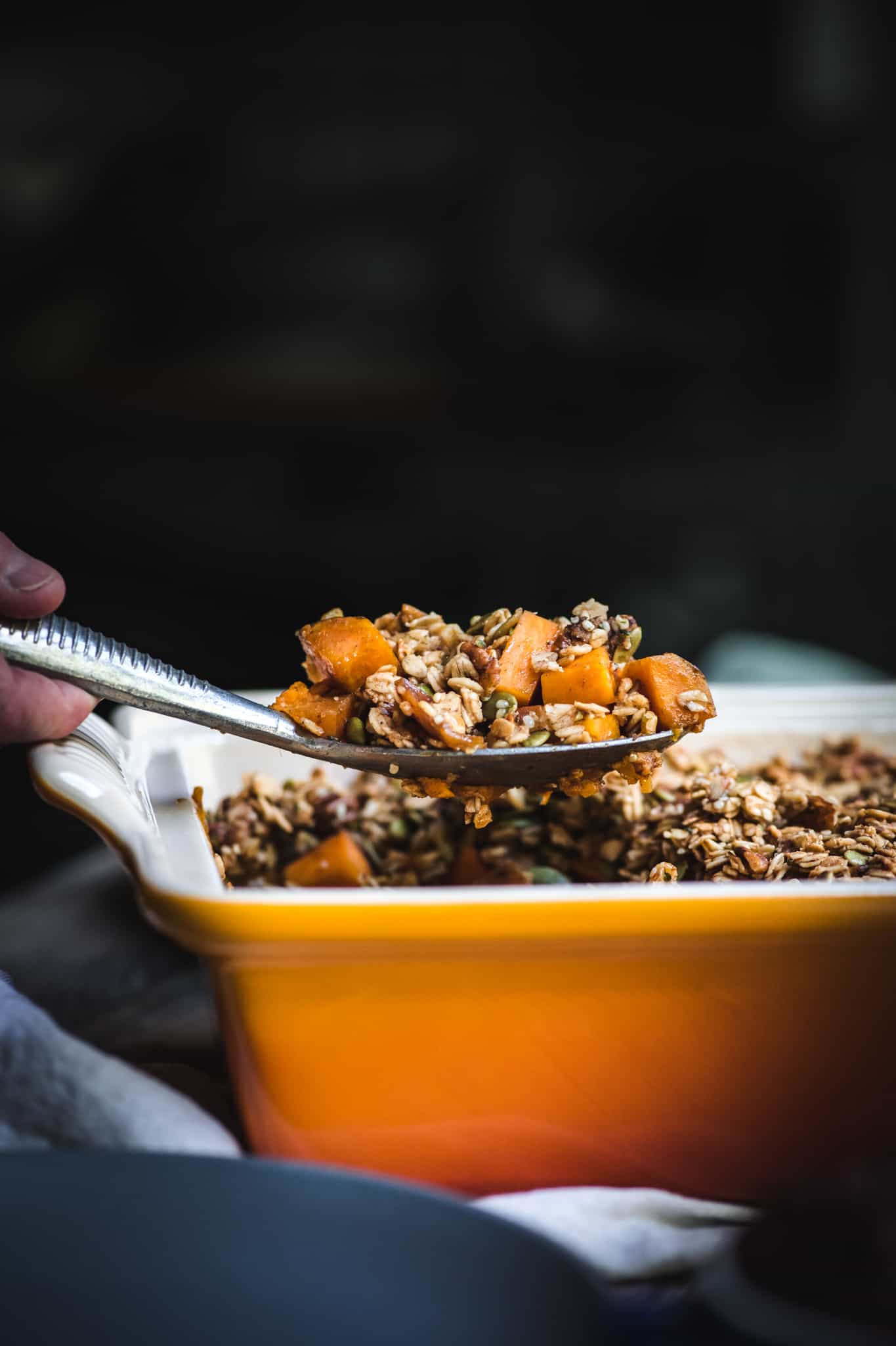 Side view of lifting sweet potato bake out of casserole dish