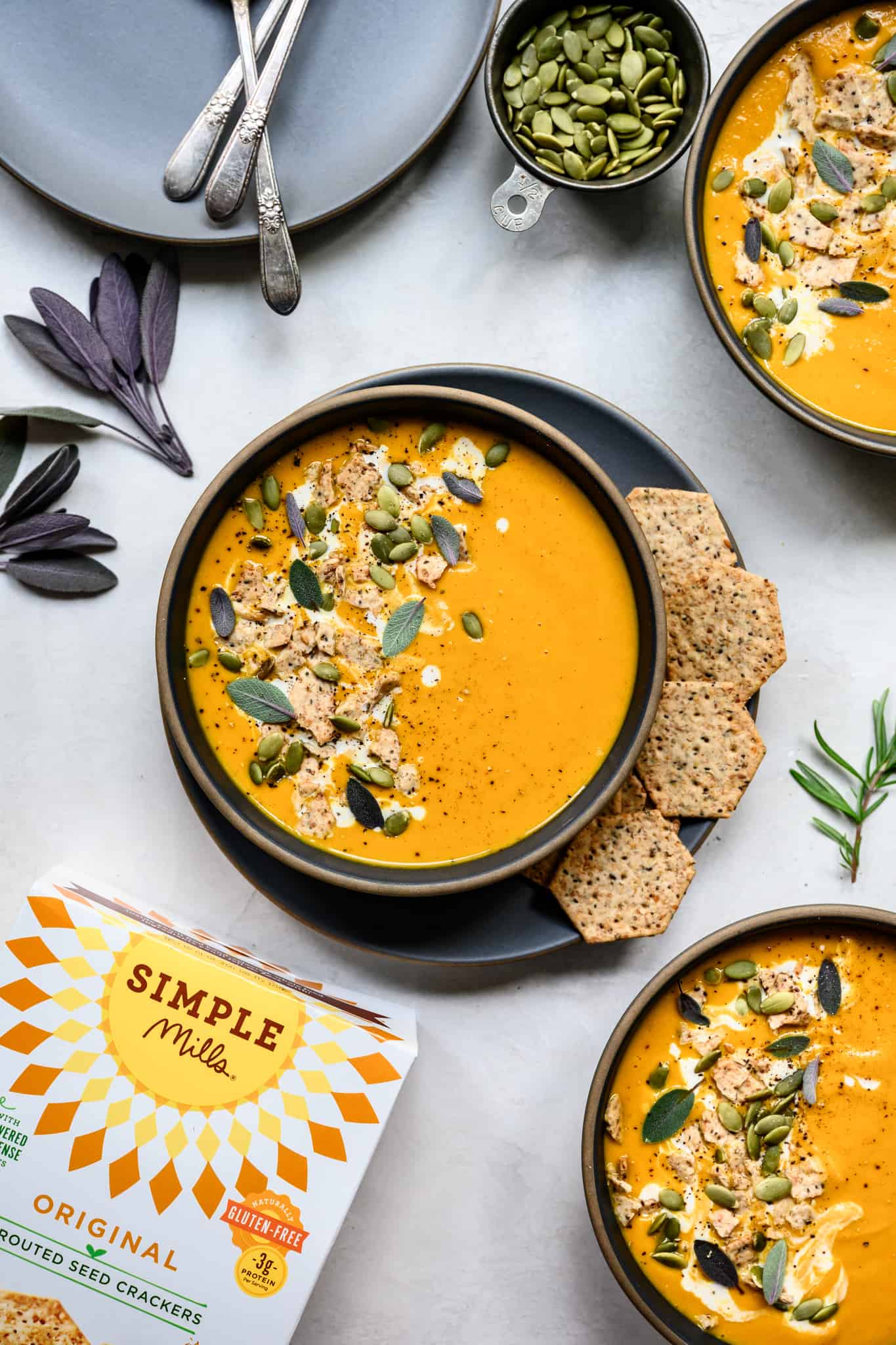 overhead view of vegan pureed carrot ginger soup with simple mills crackers on the side