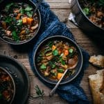 overhead view of 2 bowls of quinoa vegetable stew on wood table