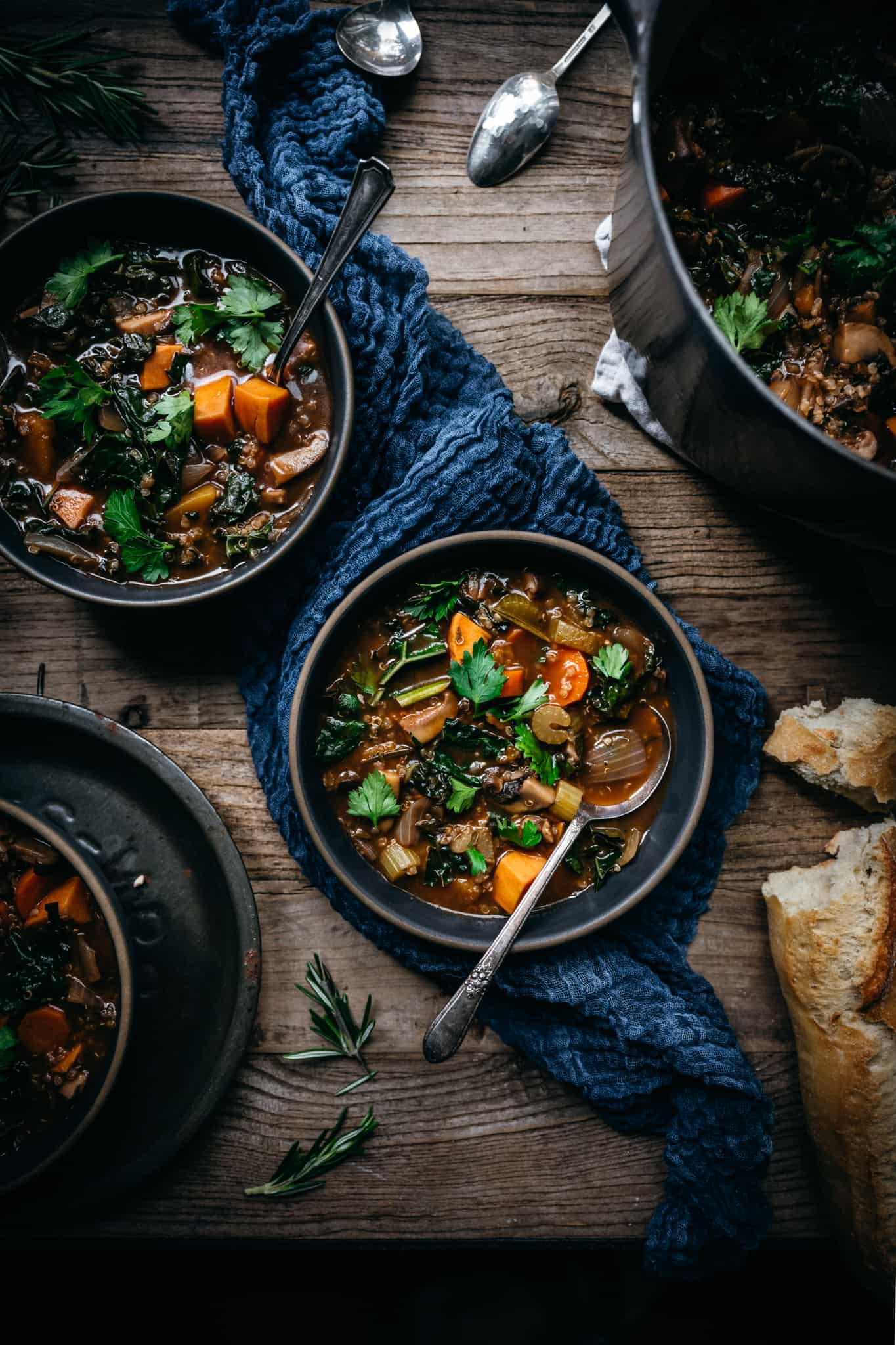 overhead view of 2 bowls of quinoa vegetable stew on wood table