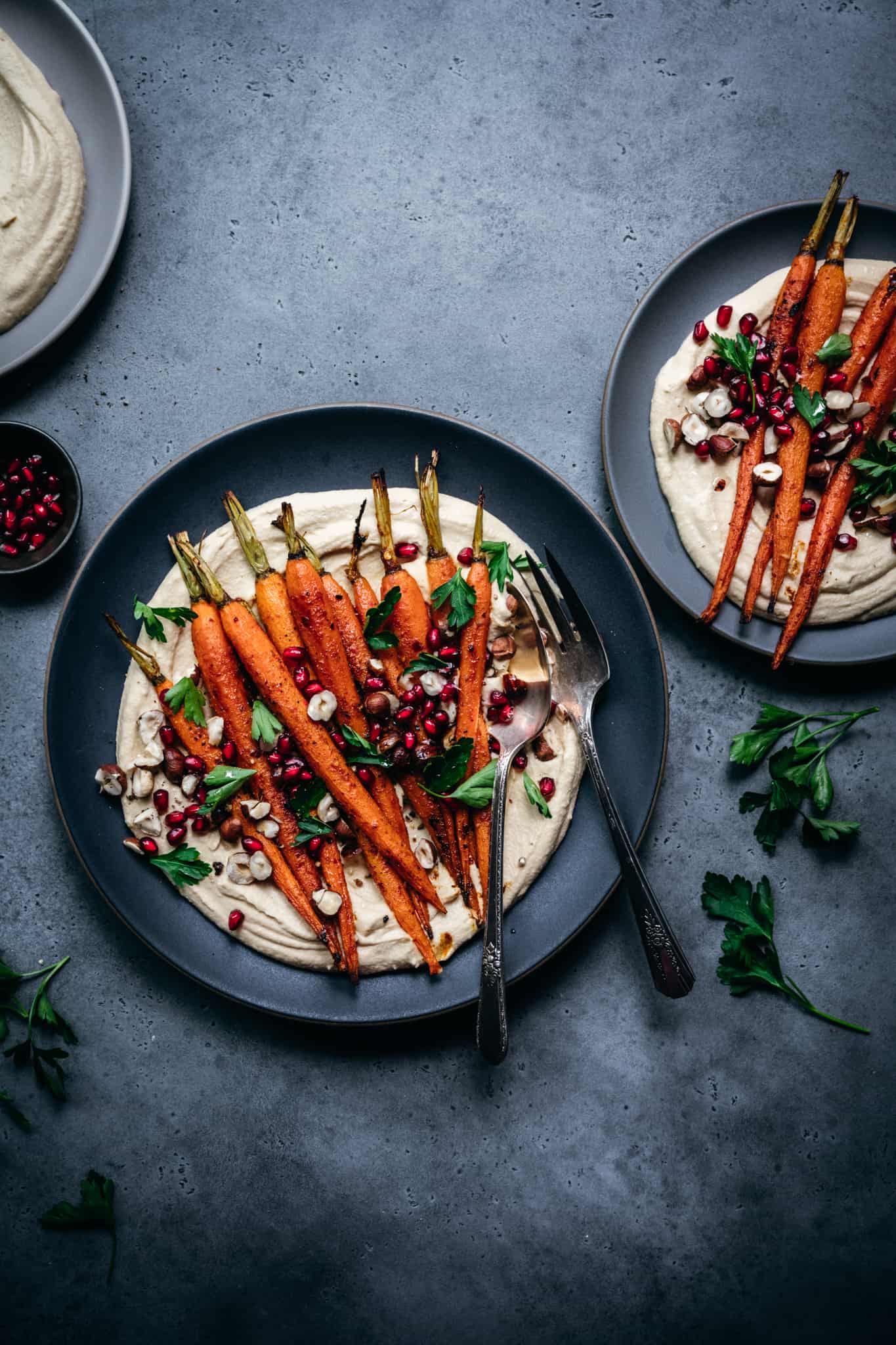 overhead view of harissa roasted carrots over a bed of hummus