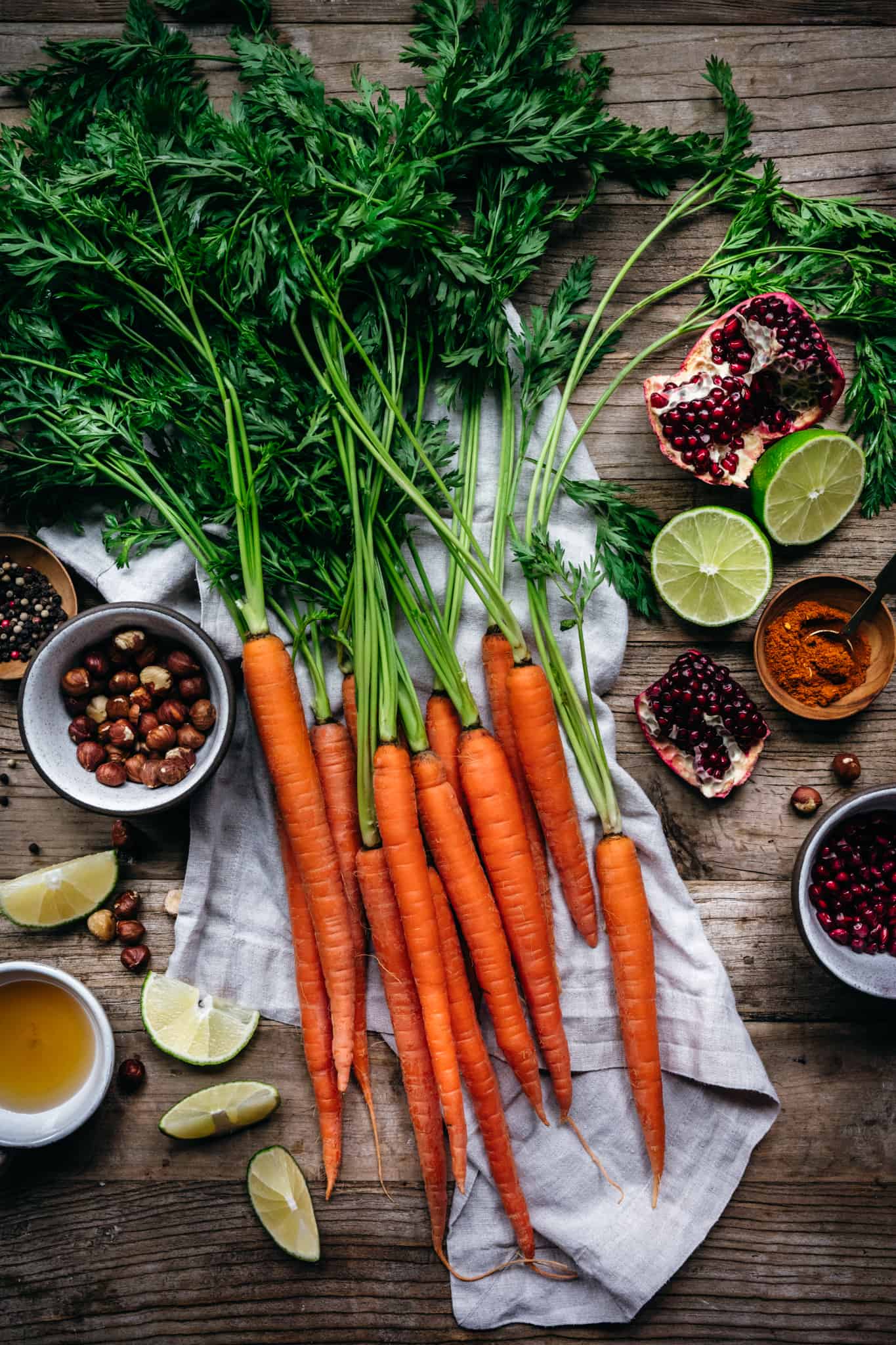 overhead of the raw ingredients for harissa roasted carrots on a wooden background