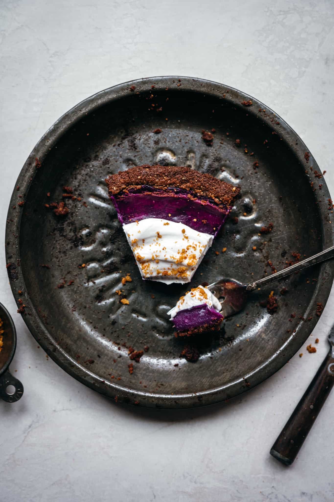 overhead view of slice of purple pie in antique pan