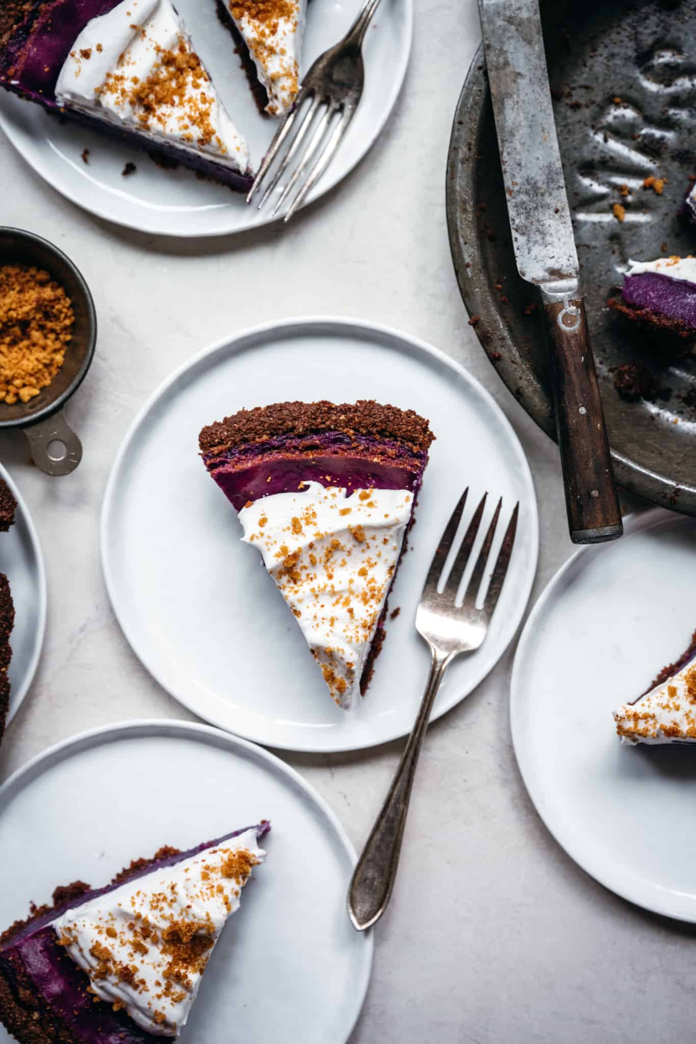 overhead view of slices of vegan purple sweet potato pie on white plates