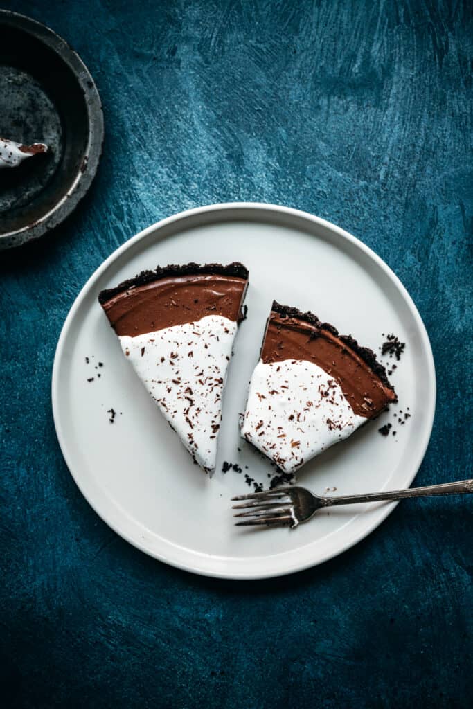 overhead view of large white plate with two slices of chocolate pie and a fork