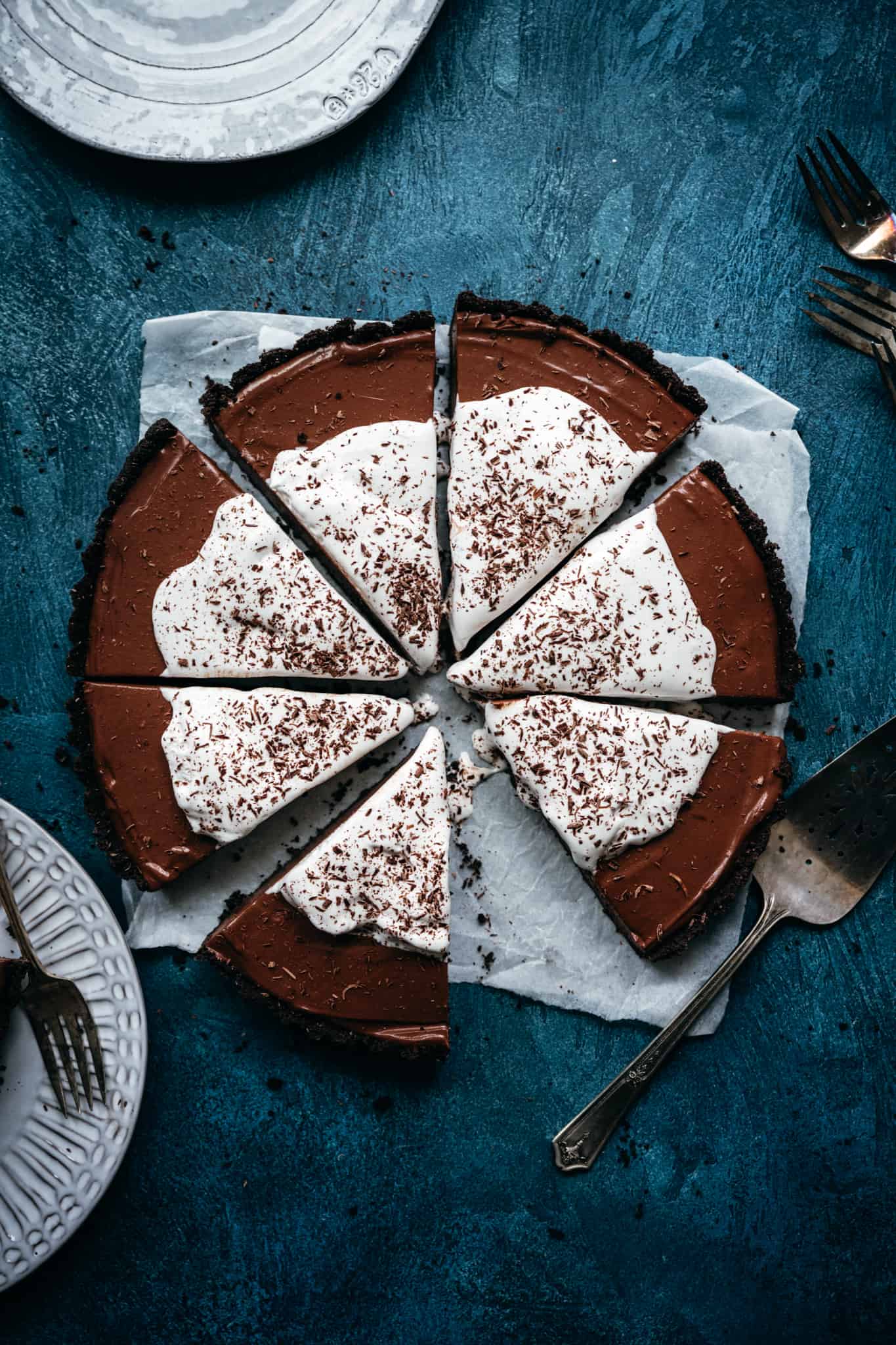 overhead view of vegan chocolate pie with whipped cream sliced into pieces