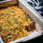 45 degree overhead of vegan breakfast casserole with one piece taken out in a baking dish