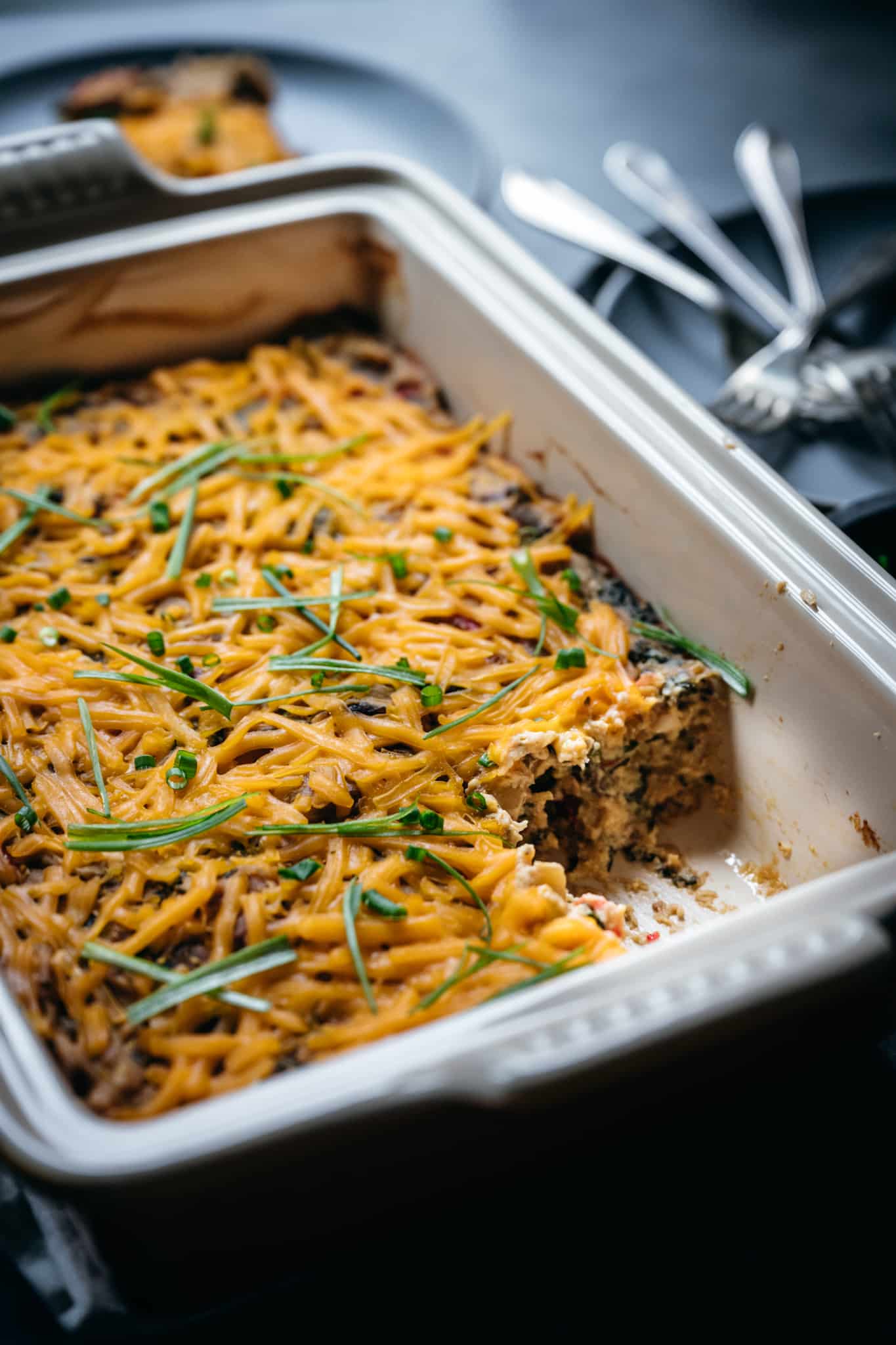 45 degree overhead of vegan breakfast casserole with one piece taken out in a baking dish