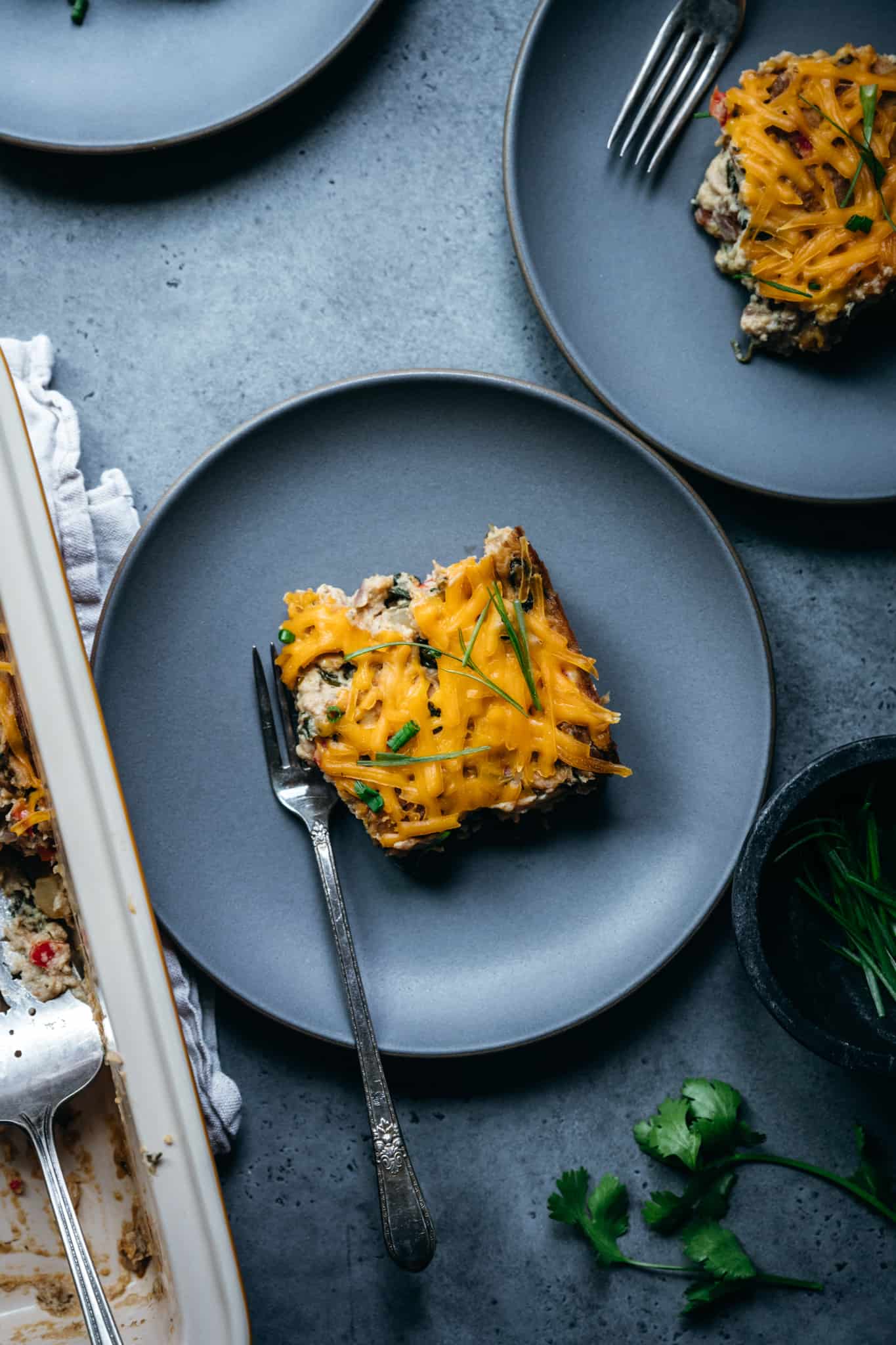 overhead of one piece of vegan breakfast casserole on a blue plate with a fork