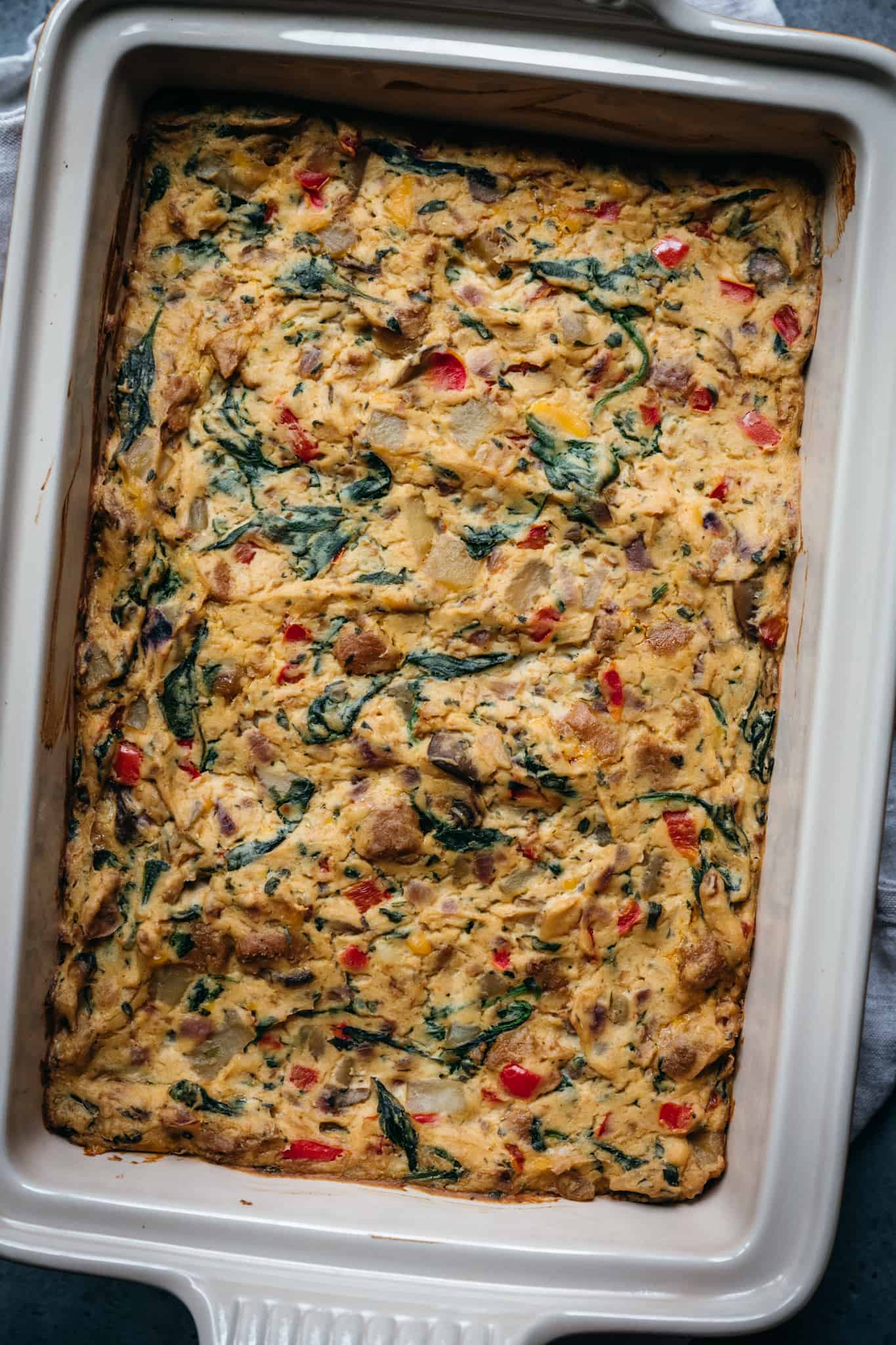 overhead of vegan breakfast casserole in a white baking dish before it's cooked
